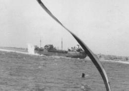 Photograph taken from USS Pivot (AM-276) in the Pacific in 1945 of an unknown Escambia class vessel being hit